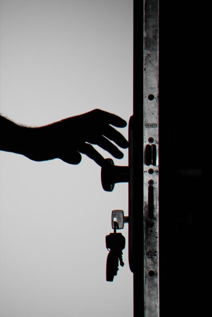 pexels-photo-792032 Silhouette of a hand about to open a door with keys in lock, symbolizing security.